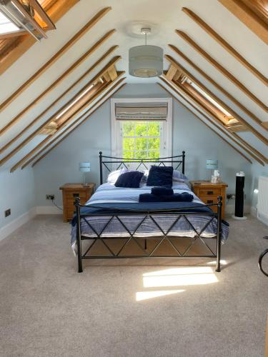 a bedroom with a bed with blue sheets and a window at The stable near the business park tube Harry Potter airports in Croxley Green