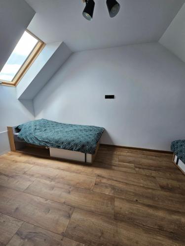 a room with a bed in the corner with a window at Zielony Zakątek in Ramleje