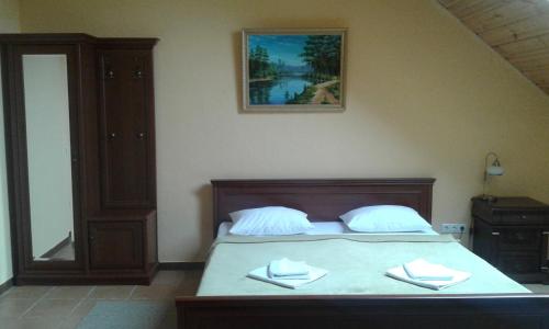 a bedroom with a bed with two towels on it at Chalet Hotel in Zhytomyr