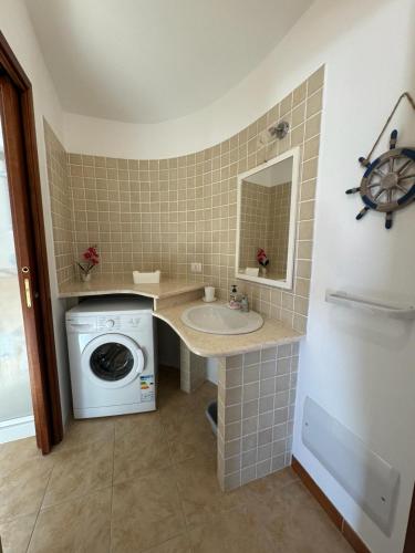 Un baño con lavadora y lavabo. en Federica's House, en Olbia