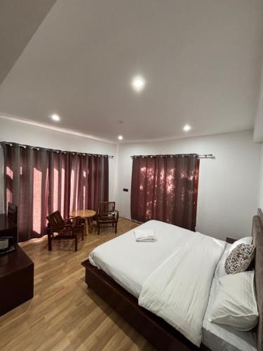 a bedroom with a large bed and a table at BARCHA Guest house in Leh