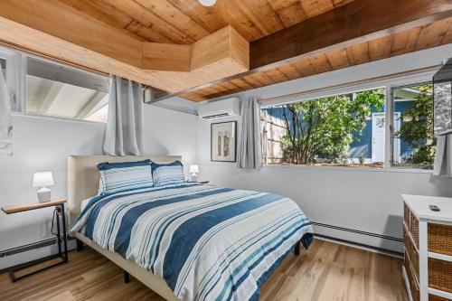 a bedroom with a bed and two windows at 10 Bunker Circle Sandwich - The Clubhouse Retreat in Sandwich