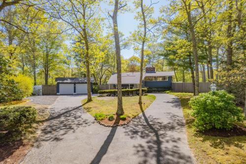 a driveway with trees and a house in the background at 10 Bunker Circle Sandwich - The Clubhouse Retreat in Sandwich