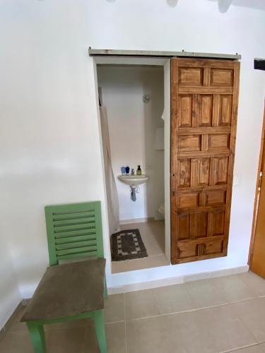 a bathroom with a green chair and a sink at El Aldabón - Villa de Leyva in Villa de Leyva