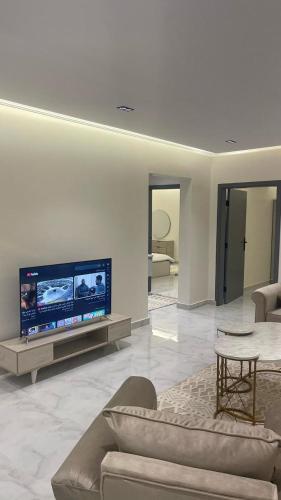 a living room with a large flat screen tv at غرفتين وصالة فندقية واسعة in Al Kharj