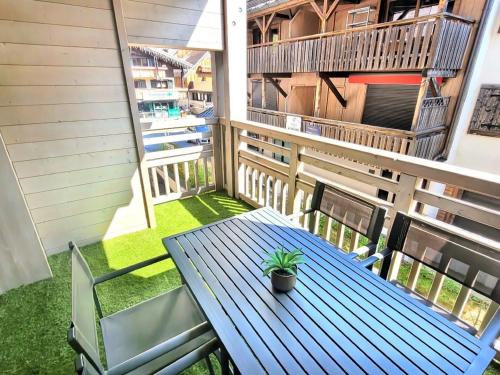 une table bleue et des chaises sur un balcon dans l'établissement Appartement moderne aux Gets, 4 pers, centre, wifi, parking - FR-1-598-64, aux Gets