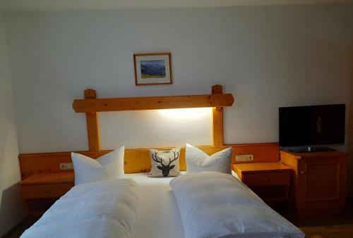 a bedroom with two beds with a stuffed cat sitting on top at Gästehaus Annemarie in Reit im Winkl