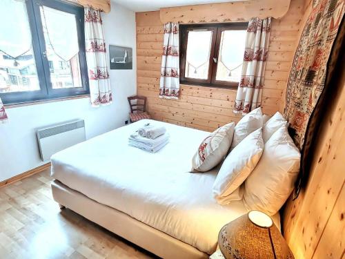 une chambre avec un lit dans une pièce avec des fenêtres dans l'établissement Appartement 3 pièces au centre des Gets, balcon, proche pistes, commerces et restaurants, 5 pers. - FR-1-598-73, aux Gets