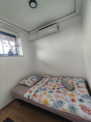 a small bedroom with a bed and a window at Studio apartman Trg in Županja