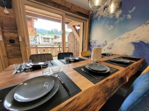 une table en bois avec des assiettes et des verres au-dessus dans l'établissement Appartement de charme au centre des Gets, proche pistes, 8 pers - moderne et équipé - FR-1-598-150, aux Gets