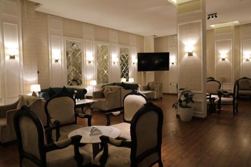 a hotel lobby with chairs and tables and a television at جولدن هافن Golden Haven in Ahad Rafidah