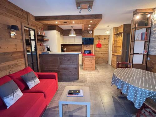 un salon avec un canapé rouge et une table dans l'établissement Appartement cosy aux Gets, balcon et parking au centre - FR-1-598-184, aux Gets