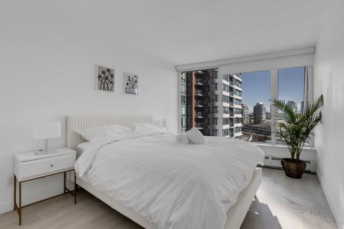 Ένα ή περισσότερα κρεβάτια σε δωμάτιο στο Bright 3BR Downtown Vancouver Condo w Pool & Gym
