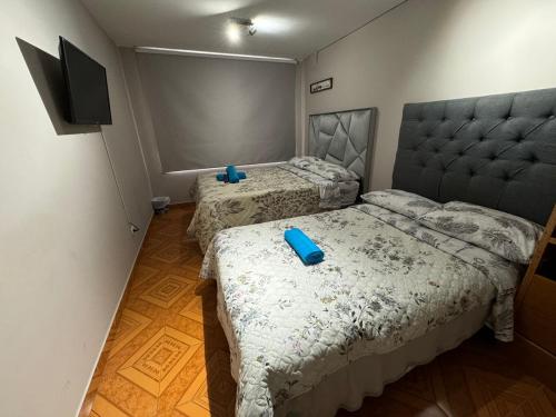 a bedroom with two beds with blue glasses on them at Gato Neon Hostel in Bogotá