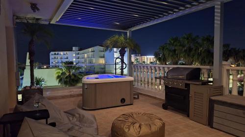 a room with a hot tub on a balcony at Nissi Golden Sands Paradi in Ayia Napa