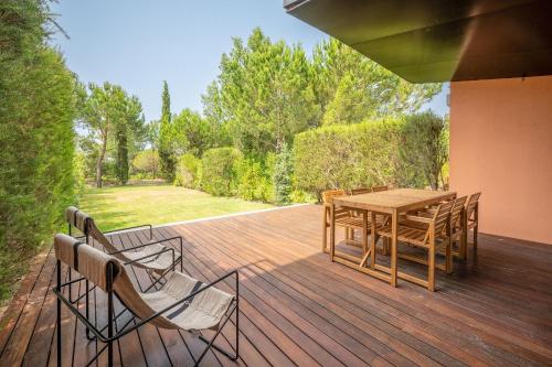 una terrazza in legno con tavolo e sedie in legno di Stunning Tróia II by LovelyStay a Tróia