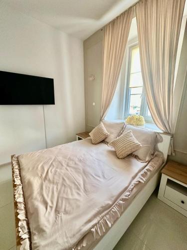 a bedroom with a white bed with a window at Pensjonat na Brackiej in Nysa
