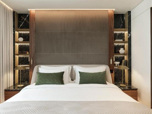 a bedroom with a large white bed with green pillows at Anthology of Athens, The Leading Hotels of the World in Athens