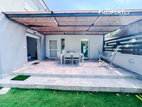 Un patio con una mesa y sillas. en Cosega Luxury Villa #PROPERTLY, en Nea Kalikratia