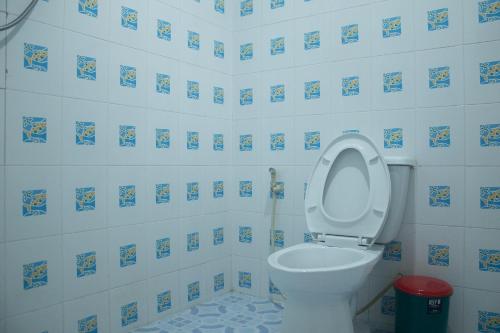 a bathroom with a toilet with blue and white tiles at Sunee Seafood Bungalow in Ban Pak Klang