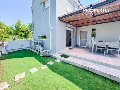 patio trasero con patio con césped en Cosega Luxury Villa #PROPERTLY, en Nea Kalikratia