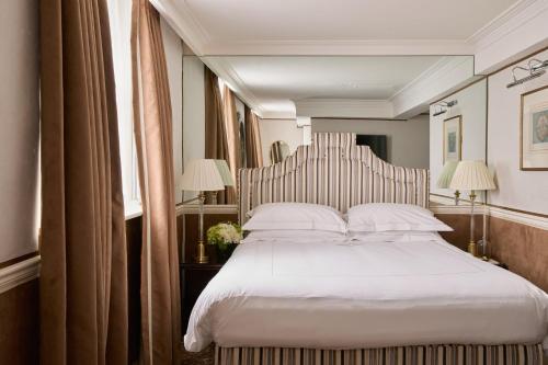 a bedroom with a large bed with white sheets and pillows at The Montague On The Gardens in London