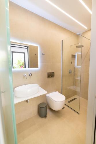 a bathroom with a sink and a toilet and a shower at Lithitsa Lofts and Suites in Parga