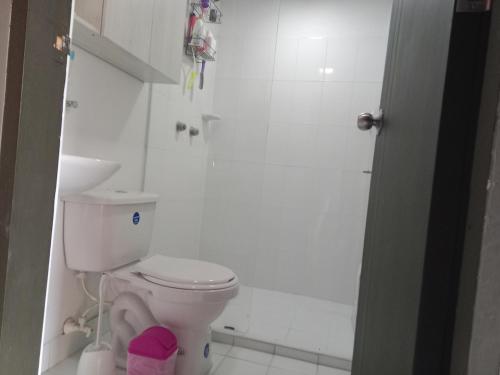 a white bathroom with a toilet and a shower at Study by Los Molinos in Estación El Salto