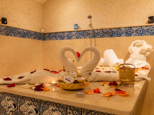 two swans sitting on a table in a bathroom at Hotel LA PALOMA in Tetouan