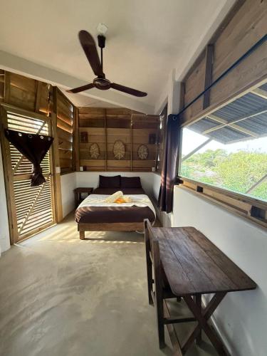 a bedroom with a bed and a table and a ceiling fan at Casa Gitana in Chamuscadero