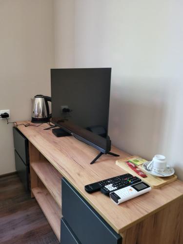 a desk with a television and a remote control on it at Balkan Aparts in Hisarya