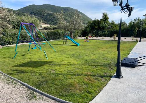 a park with a playground with two swings at Valley House in Vasiliki