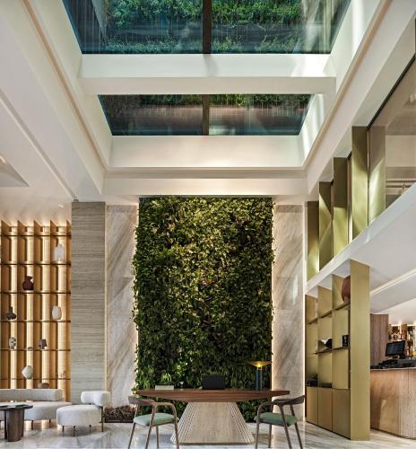 a living wall in a lobby with a table and chairs at Anthology of Athens, The Leading Hotels of the World in Athens