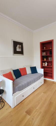 - un lit blanc avec des oreillers colorés dans l'établissement Studio Confortable Sirius Centre Ville Rouen, à Rouen