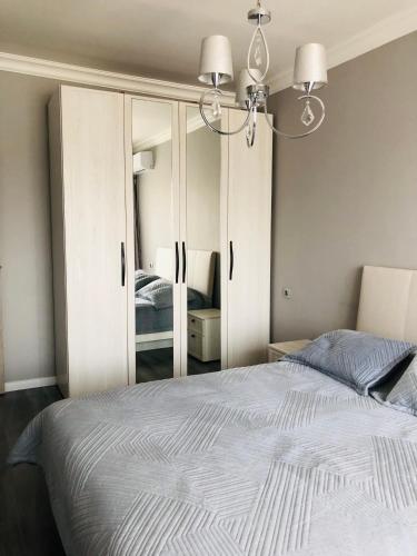 une chambre avec un grand lit et un miroir dans l'établissement Светлая квартира в центре, à Almaty