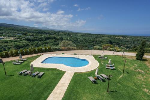 an aerial view of a swimming pool in a grass field at Arodamos Villa with a pool, children's games, and BBQ, perfect for 23 people! in Skouloúfia