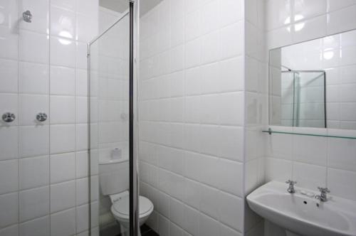 a white bathroom with a toilet and a sink at Vetho 2 Apartments OR Tambo Airport in Kempton Park