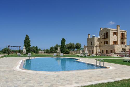 a large swimming pool in front of a building at Arodamos Villa with a pool, children's games, and BBQ, perfect for 23 people! in Skouloúfia