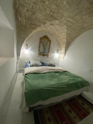 a bedroom with a bed in a stone wall at Traditional Medina House - Entire Home in Tunis