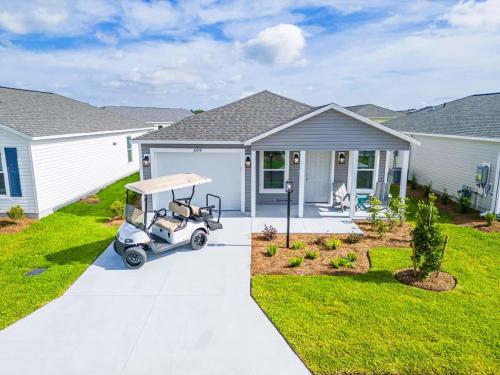 リーズバーグにあるBrand New 2-2 Villa with Golf Cartの家の前に停められたゴルフカート