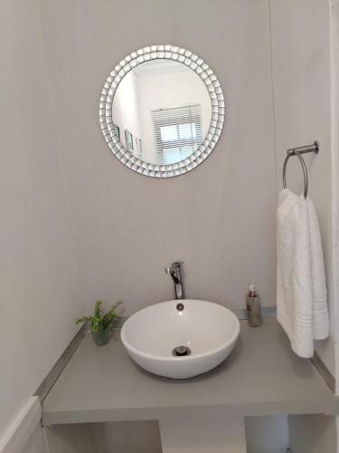 a bathroom with a white sink and a mirror at Faerie Glen B&B in Pretoria
