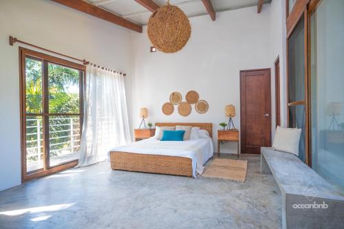a bedroom with a bed and a large window at SantiChanti Walk to Sunzal Beach in Tamanique