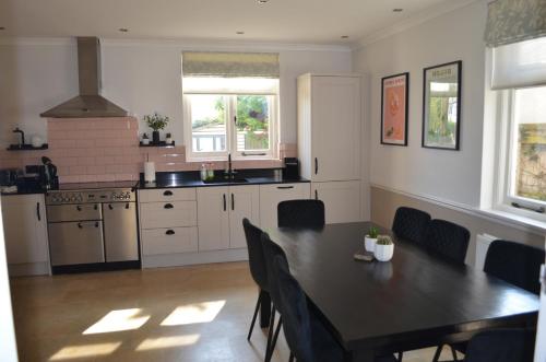 a kitchen with a table and a table and chairs at Lily House in Minehead