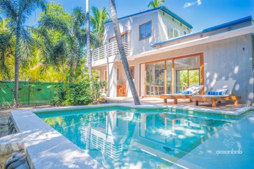 a swimming pool in front of a house at SantiChanti Walk to Sunzal Beach in Tamanique