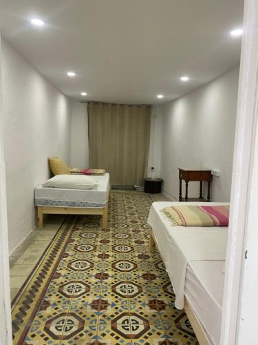 a room with two beds and a rug at Traditional Medina House - Entire Home in Tunis