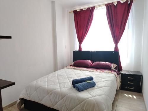 a bedroom with a bed with two blue towels on it at Apto turístico a 5mn de la Basílica - Chiquinquirá in Chiquinquirá
