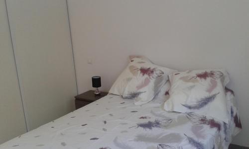 un lit avec deux oreillers dessus dans l'établissement T3 vue Mer, à San-Martino-di-Lota