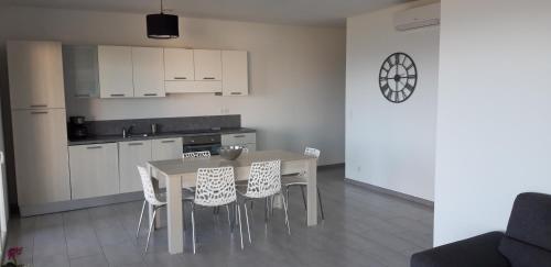 une cuisine avec une table et quelques placards blancs dans l'établissement T3 vue Mer, à San-Martino-di-Lota