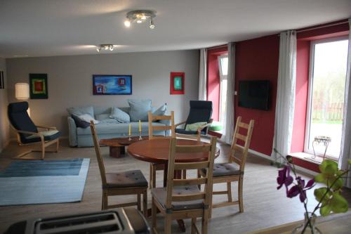 Una sala de estar con una mesa y sillas y un sofá. en Ferienhaus Waldrand In Ascheffel, en Hütten
