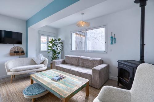 Una sala de estar con un sofá y una chimenea. en Maison des Bouillats - Welkeys, en Saint-Trojan-les-Bains